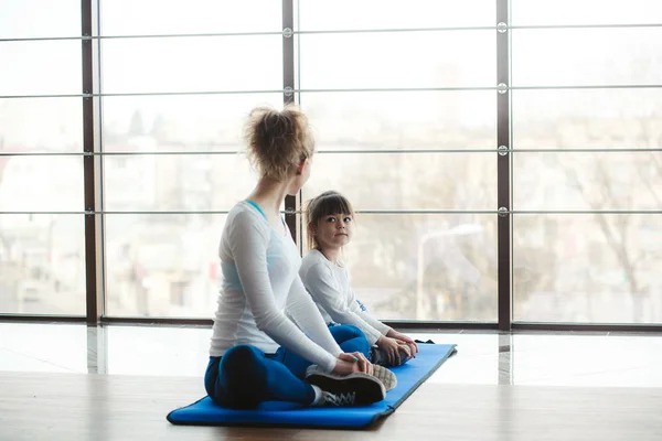 Twee meisjes van verschillende leeftijden maken van yoga — Stockfoto