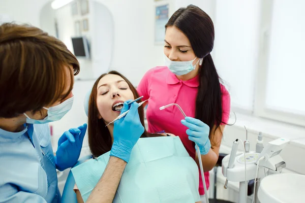 Dentista assistente e o paciente na clínica . — Fotografia de Stock