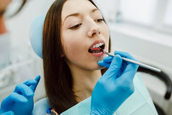 Dentista assistente e o paciente na clínica . — Fotografia de Stock