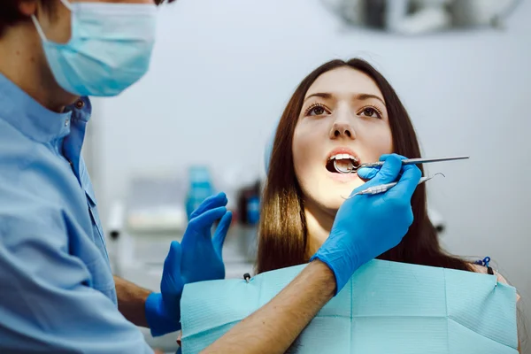 Inspección de los dientes de la niña con la ayuda de un espejo — Foto de Stock