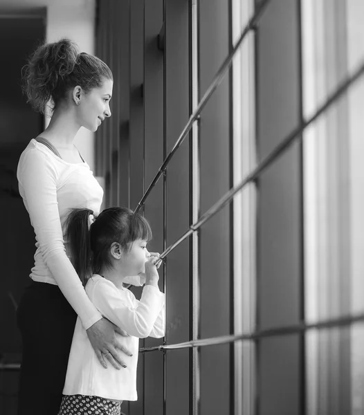 Dos chicas de diferentes edades miran fijamente en una ventana del gimnasio —  Fotos de Stock