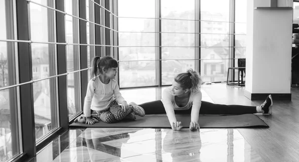 Madre e hija haciendo yoga en el gimnasio —  Fotos de Stock