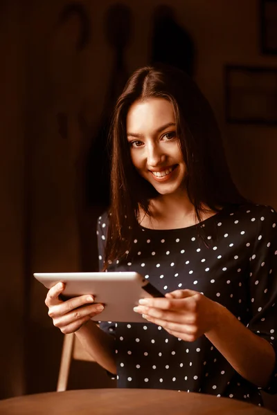 Krásná dívka pracuje na tabletu a usmívá se — Stock fotografie