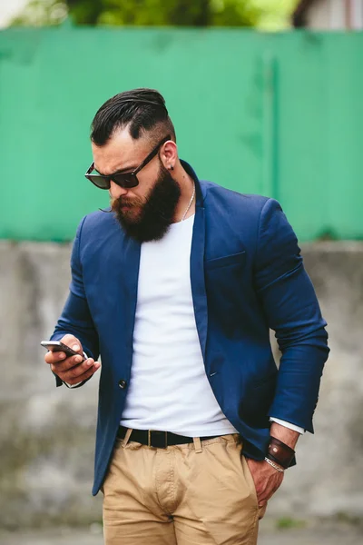 Homem de negócios barbudo olhando para o telefone — Fotografia de Stock