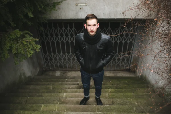 A man dressed in jeans and black jacket on autentic stairs — Stock Photo, Image