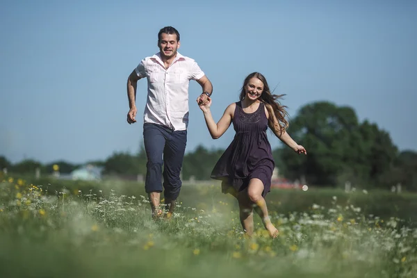 Par som springer i fält — Stockfoto