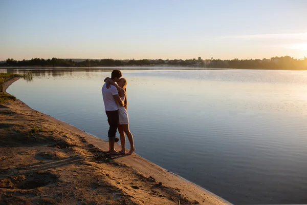 Paar im Sonnenaufgang am Strand — Stockfoto