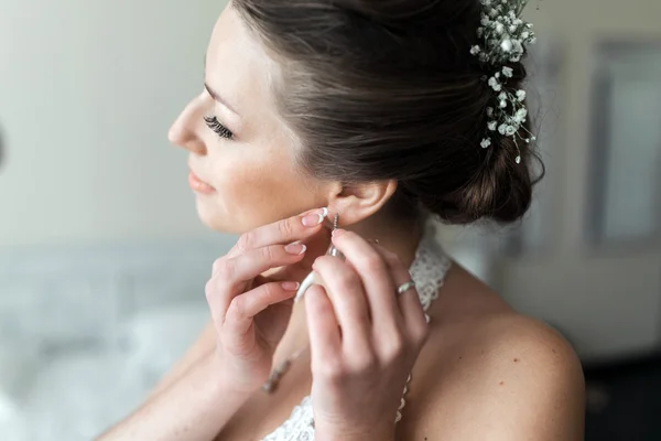 Bride puts on earrings — Stock Photo, Image