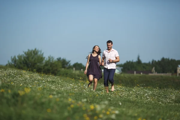 Paar läuft auf Feld und hat Spaß — Stockfoto