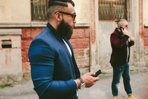 Barbuto uomo d'affari guardando il telefono — Foto Stock