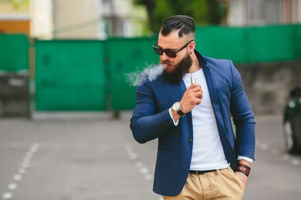 Well-dressed man smoking electronic cigarette — Stock Photo, Image