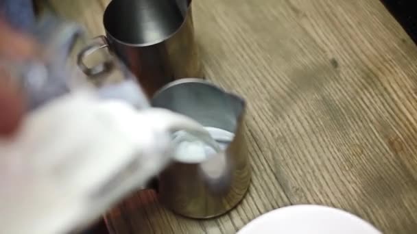 Barista vertiendo leche en una taza de metal — Vídeos de Stock