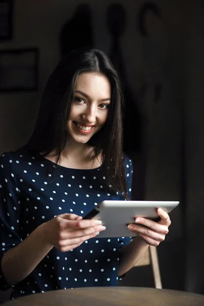 Hermosa chica trabajando en una tableta y sonriendo —  Fotos de Stock