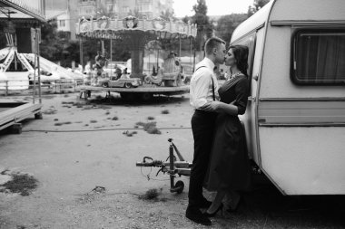 Erkek ve kadın bir karavanın arkasında saklanıyor.