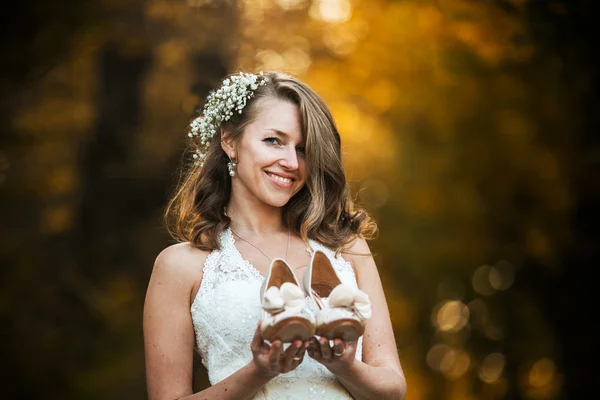 Brud holding bröllop skor — Stockfoto