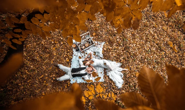 Pareja de boda acostada debajo de un árbol — Foto de Stock