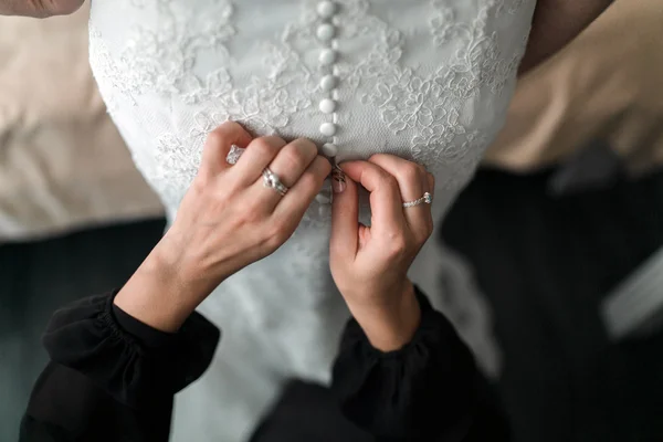 Empregada de honra ajudando a noiva com seu vestido — Fotografia de Stock