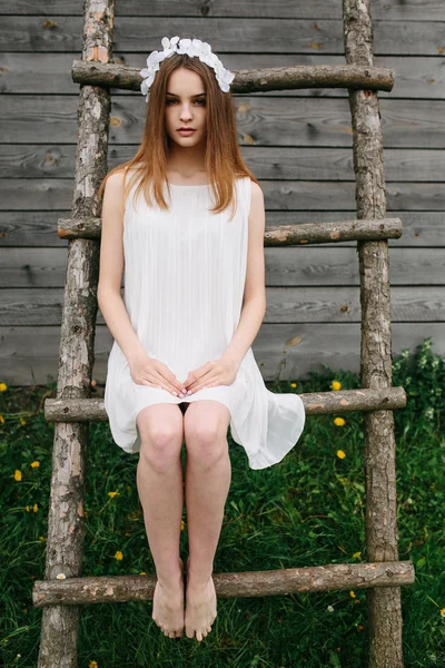 Girl climbing ladder into tree house — Stock Photo, Image