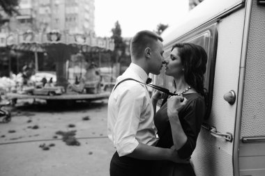 Erkek ve kadın bir karavanın arkasında saklanıyor.