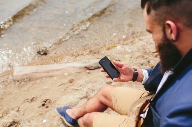 Amerikalı sakallı nehrin yanında istimal telefon adam