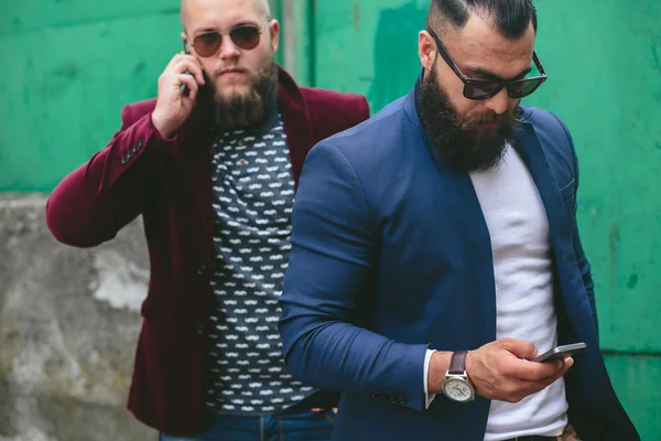 Двоє бородатих бізнесмен дивиться по телефону — стокове фото