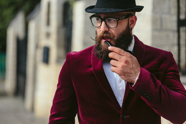 богатый человек в куртке рядом с его домом
