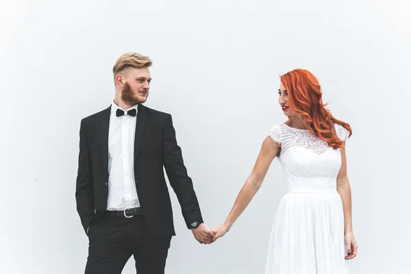 Svatební pár na pozadí bílé stěny — Stock fotografie
