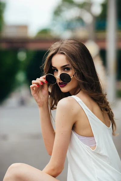 Красива дівчина в сонцезахисних окулярах сидить — стокове фото