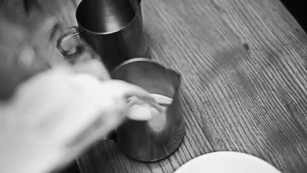 Barista hälla mjölken i en metall kopp — Stockvideo
