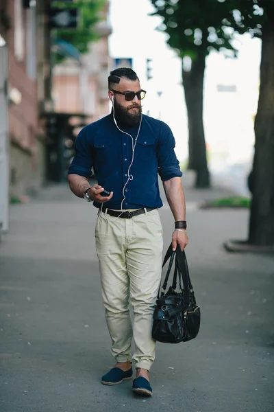 Bearded man goes and listens to music — Stock Photo, Image