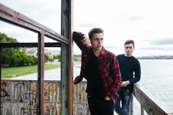 Two guys stand in an abandoned building on lake — Stock Photo, Image