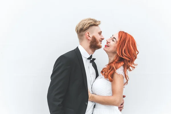 Pareja de boda en un fondo de pared blanca —  Fotos de Stock