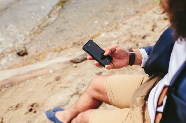 Amerikalı sakallı nehrin yanında istimal telefon adam