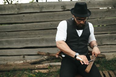 güçlü adam eski ustura keskinleştirir