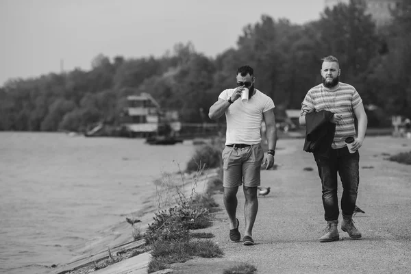 Deux hommes marchent et boivent du café — Photo