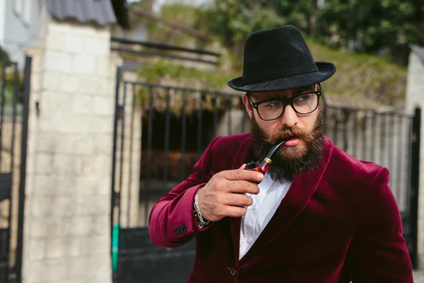 Homem rico com uma barba fuma berço — Fotografia de Stock