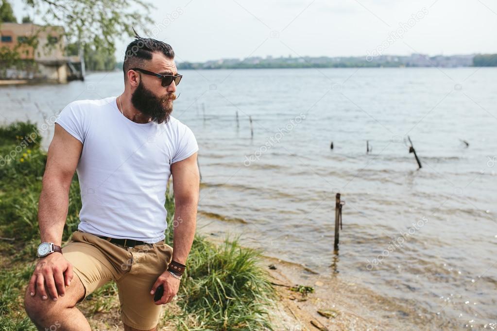 American Bearded Man looks on the river bank