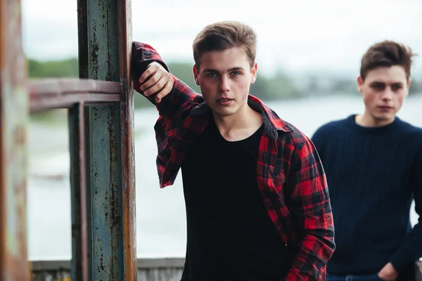 Två killar står i en övergiven byggnad på sjön — Stockfoto