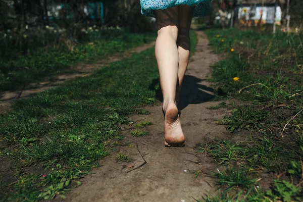 아름다운 소녀의 다리는 시골 길을 따른다 — 스톡 사진