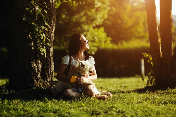 The girl with dog sit on a grass — Stock Photo, Image