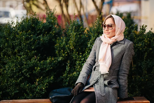 Meisje zitten op een bank in het park — Stockfoto