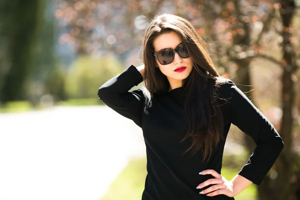 Mujer joven glamurosa en chaqueta de cuero negro y gafas de sol —  Fotos de Stock