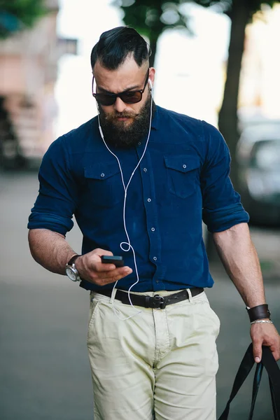 Bearded man goes and listens to music — Stock Photo, Image