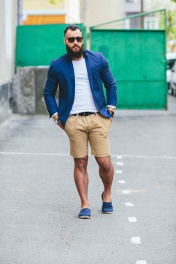 Şık sakallı adam şehirde yürüyor.