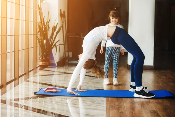 Zwei Mädchen unterschiedlichen Alters machen Yoga — Stockfoto