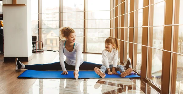 Mor och dotter att göra yoga i gymmet — Stockfoto
