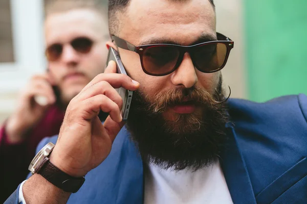 Dois empresários barbudos olhando para o telefone — Fotografia de Stock