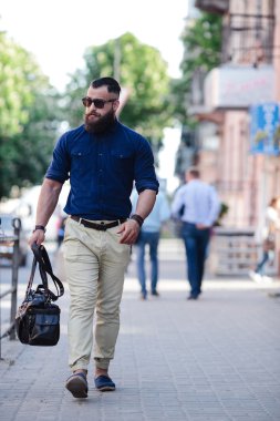 Sakallı adam gidip müzik dinliyor.