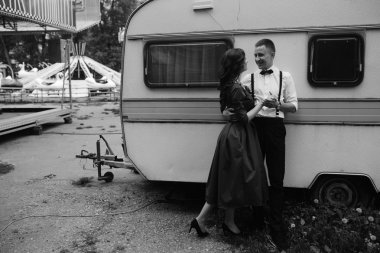 Erkek ve kadın bir karavanın arkasında saklanıyor.