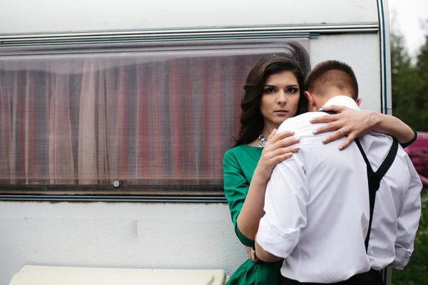 Homem e mulher está escondido de vista atrás de um trailer — Fotografia de Stock